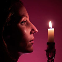 A girls profile facing a lighted candle